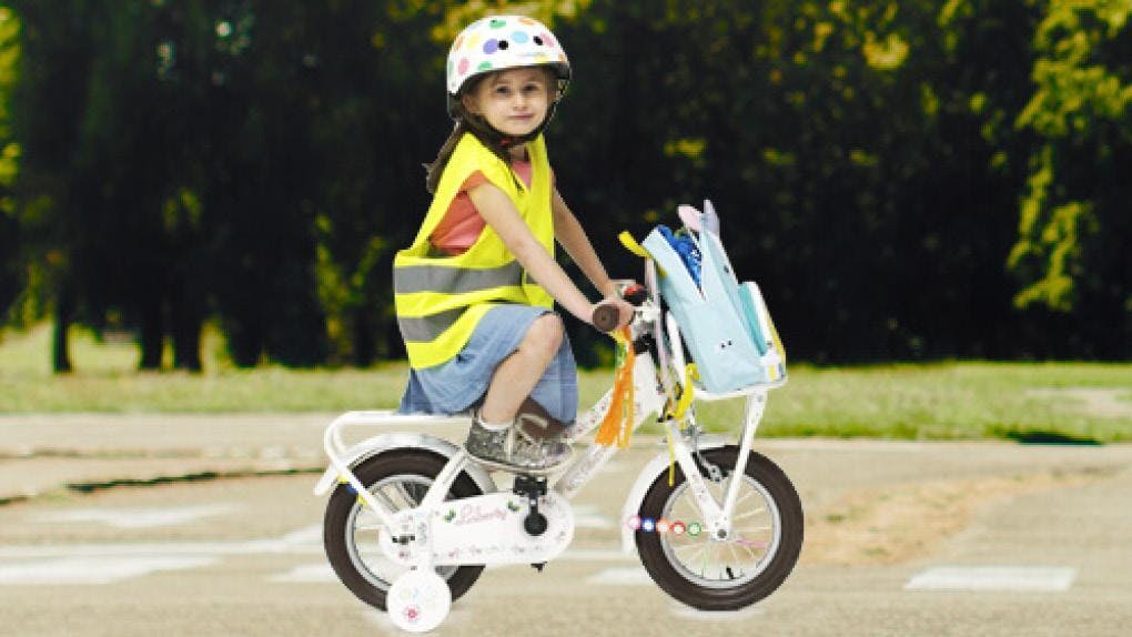 Meisje met fluohesje op kleurrijke fiets