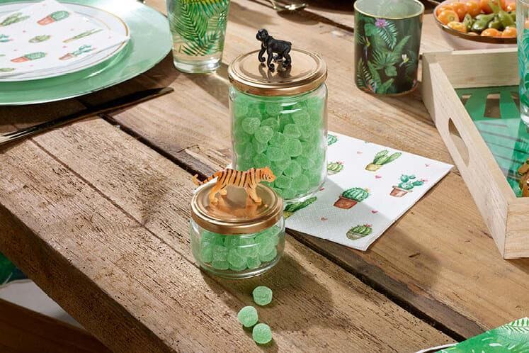 Houten tafel met groene tafelversiering en communiebedankje met jungle diertjes