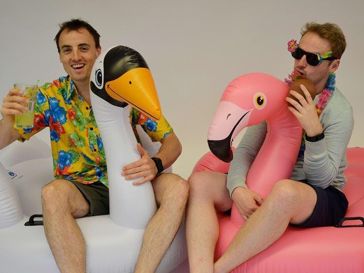 Twee mannen op opblaasdieren: een witte zwaan en een roze flamingo.
