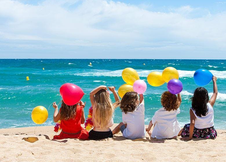 4 kinderen met ballonnen aan zee