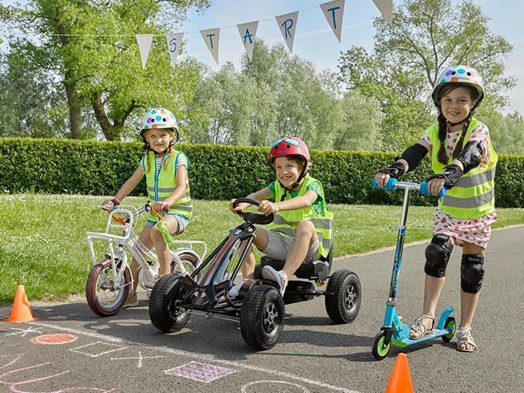3 kinderen op een fiets, gocart, step aan de startlijn