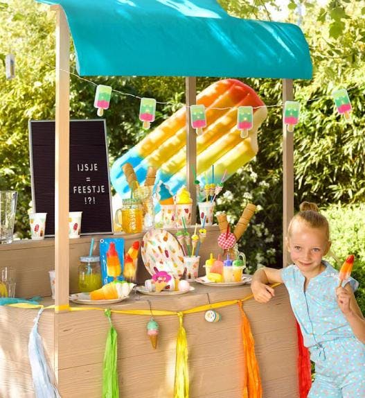 Meisje met ijsje aan een kleurrijk ijsjeskraam